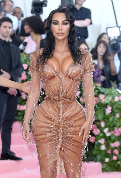 Kim Kardashian in a sheer, skin-toned dress with shimmering beads and sparkling drops.