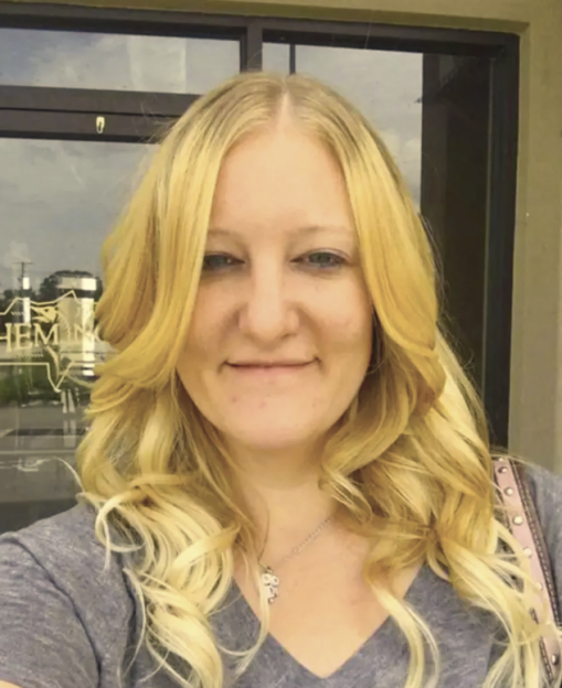 Casei Chris Jones, a woman with long blonde hair, wearing a gray t-shirt and a necklace.