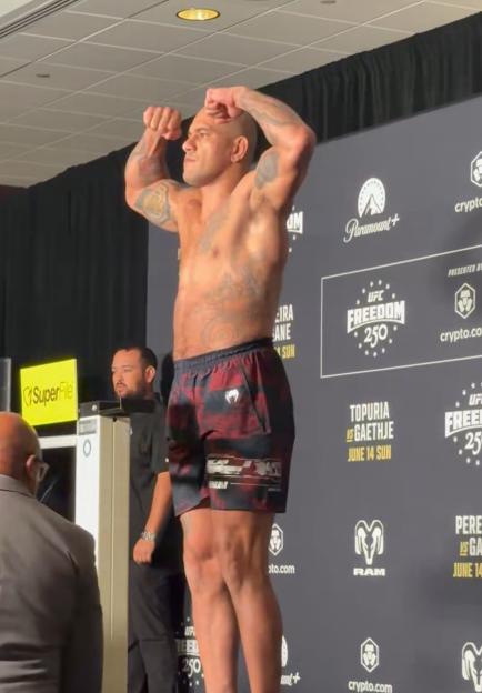 Fighter Alex Pereira flexing for the crowd at the UFC Freedom 250 weigh-in event.
