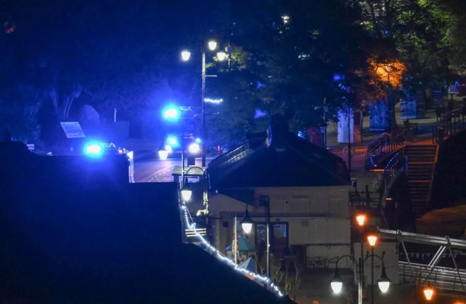 Emergency services vehicles with flashing blue lights at a scene on Newcomen Road.