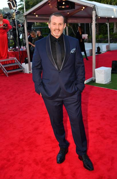 Actor Ryan Moloney wearing a dark blue suit and black tie on the Logie Awards red carpet.