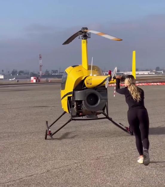 Kinsey Wolanski pushing a yellow helicopter.