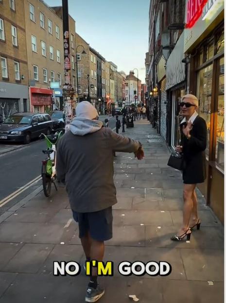 A person in a gray hoodie and blue shorts walks away from influencer BryanBoy, who is dressed in a black jacket and skirt, sunglasses, and high heels. The text "NO I'M GOOD" is at the bottom of the image.