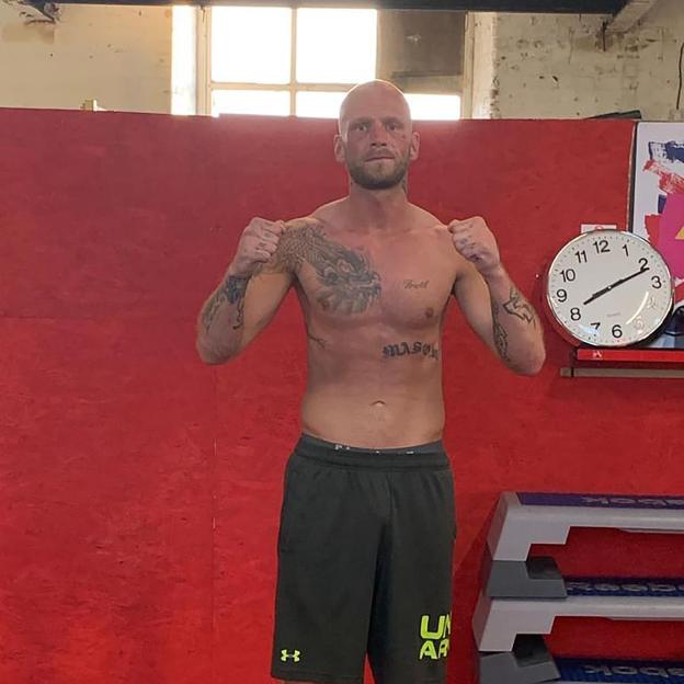 Bare-knuckle boxer Callum Kerr posing shirtless with fists raised.