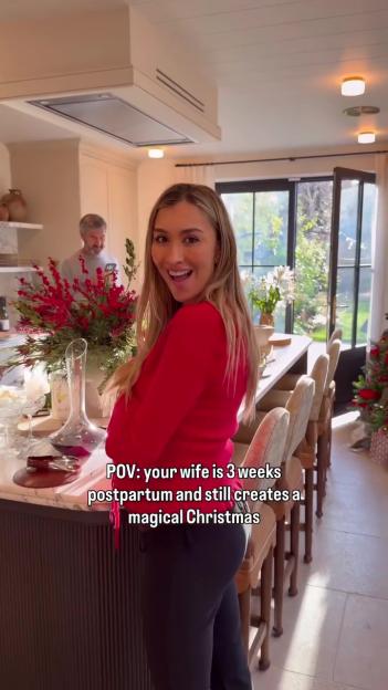 Sophie Habboo smiling and looking over her shoulder at the camera in a kitchen decorated for Christmas.