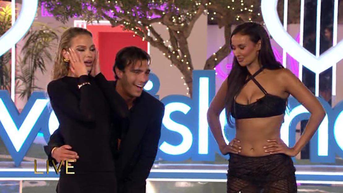 Finalists of Love Island react to the results, with the host standing beside them.