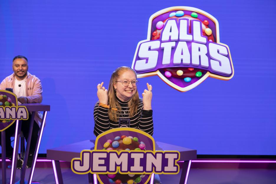 Thea Jacobs smiling and crossing her fingers at the Candy Crush All Stars competition press day.