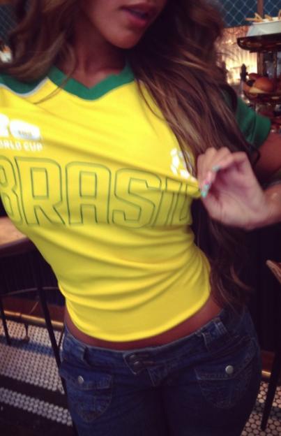 Woman wearing a yellow Brazil World Cup shirt and jeans.