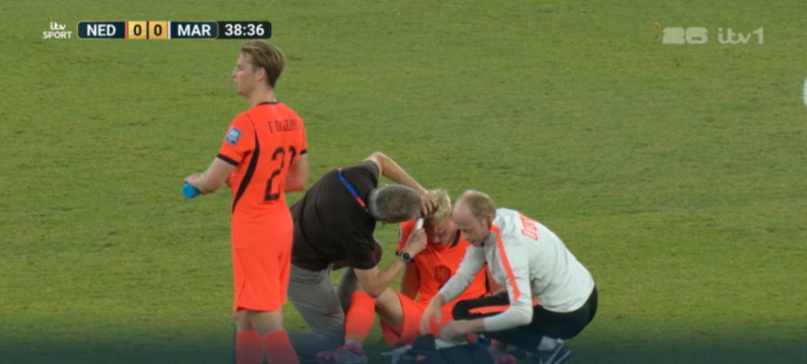 Soccer player being tended to by medical staff on the field.