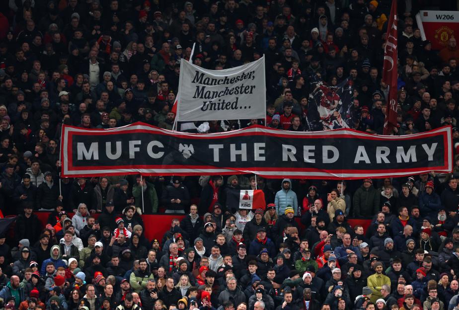 Manchester United fans hold up banners before a Premier League match.