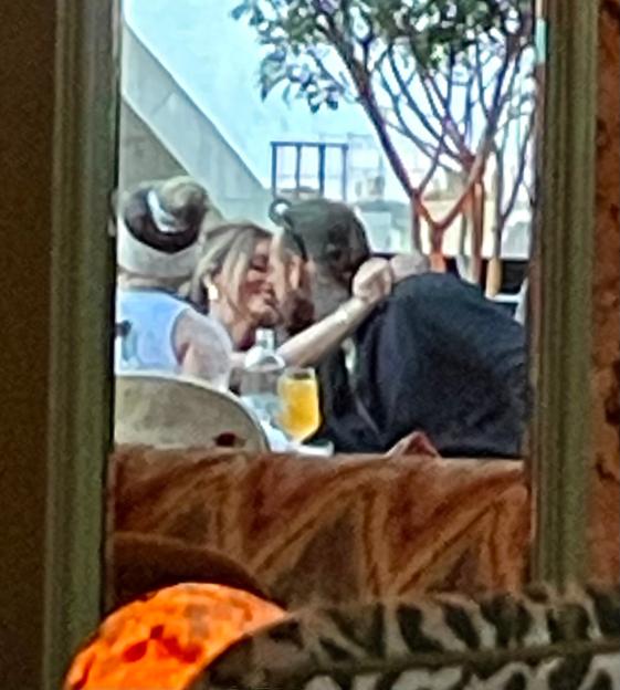 Maura Higgins and Pete Wicks embrace, leaning in for a kiss at a table.