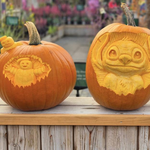 Two carved pumpkins, one with the Stay Puft Marshmallow Man and the other with Stitch from Lilo and Stitch.
