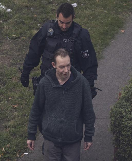Christian Brueckner being escorted by police from his residence in Neumünster, Germany.