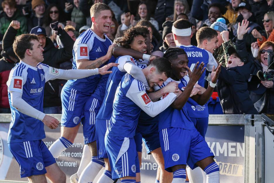 Macclesfield's English striker Isaac Buckley-Ricketts celebrates with teammates after scoring a goal during an FA Cup match.