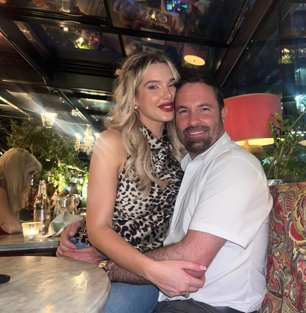 Helen Flanagan and Robbie Talbot smiling at the camera, with Flanagan sitting on Talbot's lap in a restaurant.