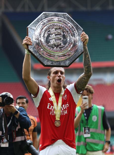 CARDIFF, WALES, AUGUST 16: Riccardo Calafiori of Arsenal holds aloft the FA Community Shield in celebration after winning the 2026 FA Community Shield during the FA Community Shield match between Arsenal v Manchester City at Principality Stadium, Car