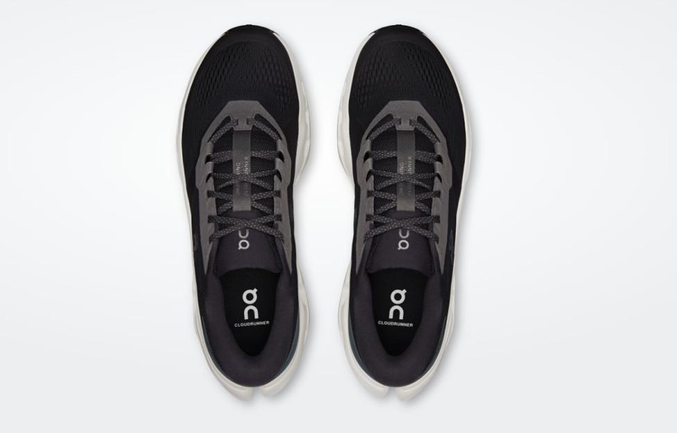 Top-down view of two black Cloudrunner running shoes with gray accents and white soles.