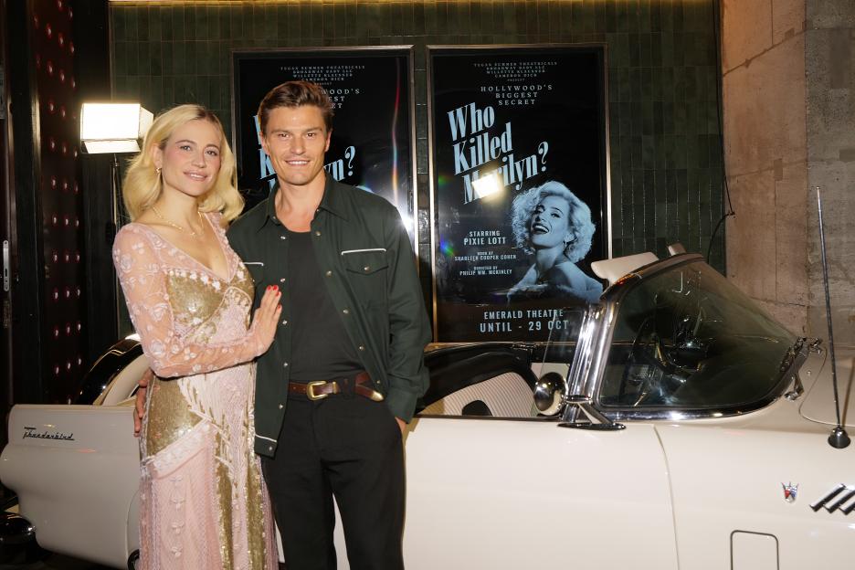Pixie Lott and Oliver Cheshire pose in front of a poster for "Who Killed Marilyn?" at an after-party.