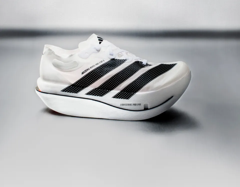 A white Adidas Adizero Adios Pro Evo 3 running shoe with black stripes and a thick sole.