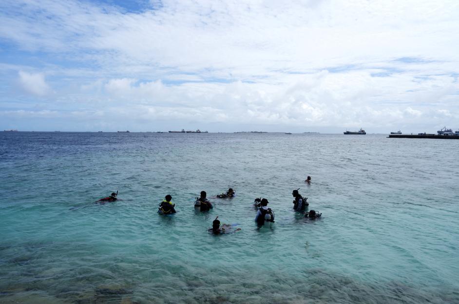 People take part in an open water diver course in coastal waters off Villingili Island