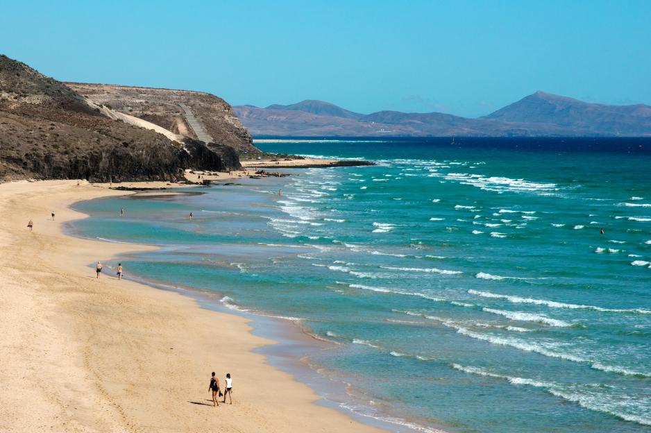 People walking on Playa del Mal Nombre beach in Fuerteventura.