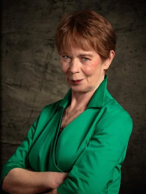 Celia Imrie, a contestant for BBC One's "The Celebrity Traitors," posing in an ornate gold frame above a mantelpiece.