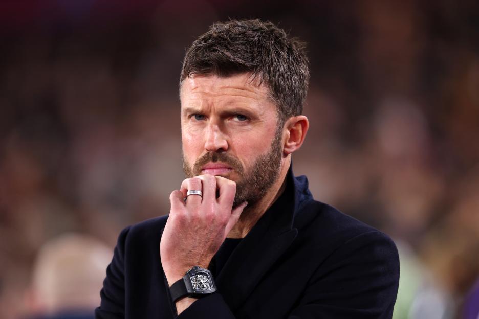 Manchester United head coach Michael Carrick watches the game with his hand on his chin.