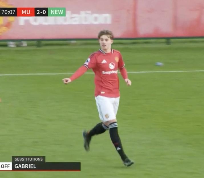 A soccer player in a red jersey and white shorts running on a green field.