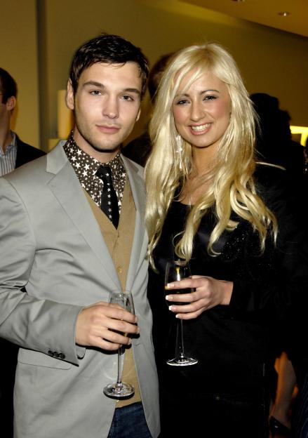 Pop stars Preston and Chantelle Houghton holding champagne flutes at the Prada and GQ Style Spring/Summer Preview Party.