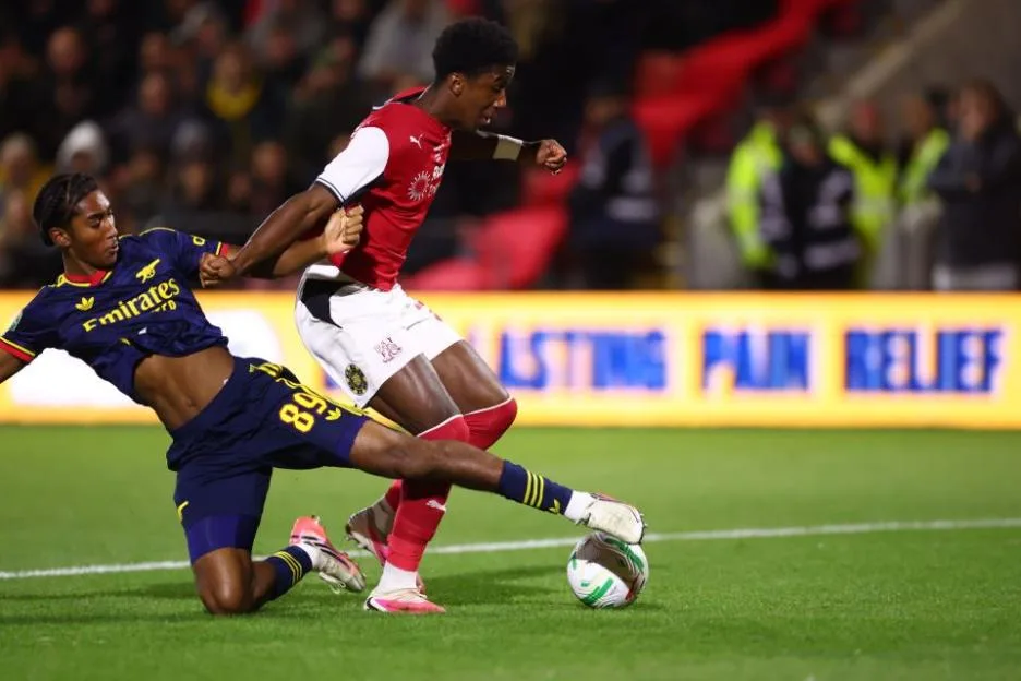 Aaron Loupalo-Bi of Fleetwood Town beats Marli Salmon of Arsenal to the ball during a match.