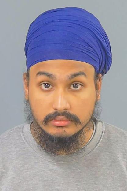 A man wearing a blue turban, a beard, and a gray sweatshirt.