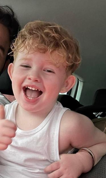 Photo of Peter Maughan, a four-year-old boy, laughing and giving a thumbs up.