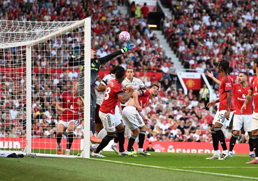 Manchester United goalkeeper Altay Bayindir attempts to save a goal.