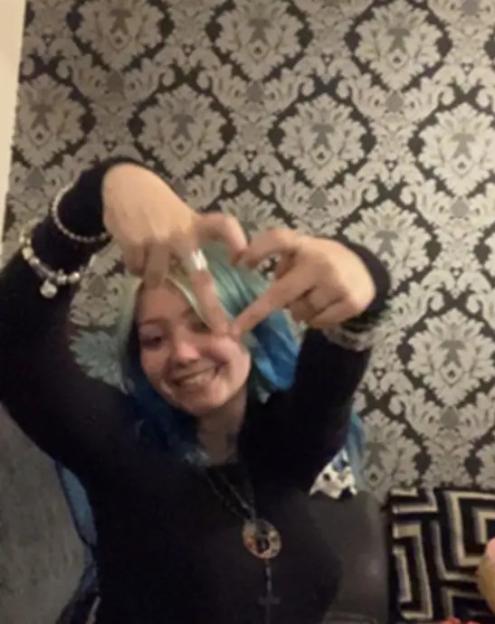 Morgan Dorsett smiling and making a heart shape with her hands.