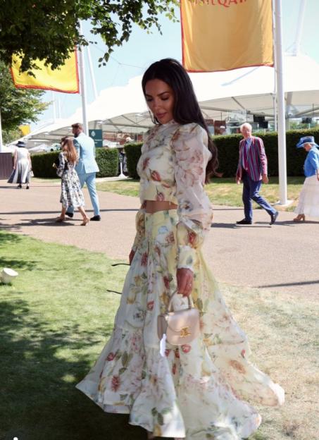 Gemma Owen wearing a floral two-piece set and holding a small handbag at Goodwood race event.