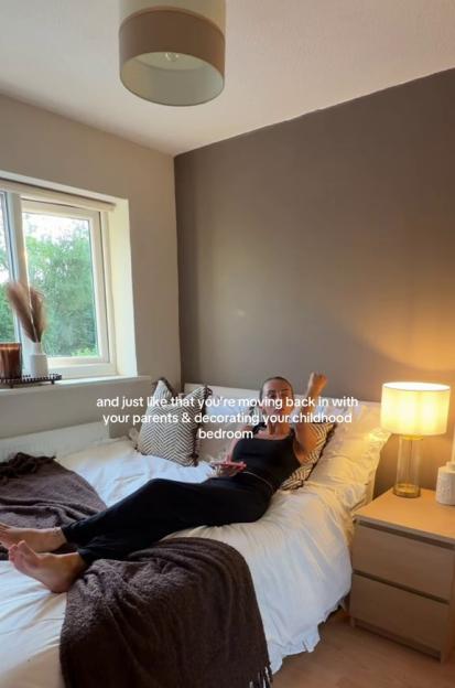 A woman lying on a bed with the overlay text "and just like that you're moving back in with your parents & decorating your childhood bedroom."