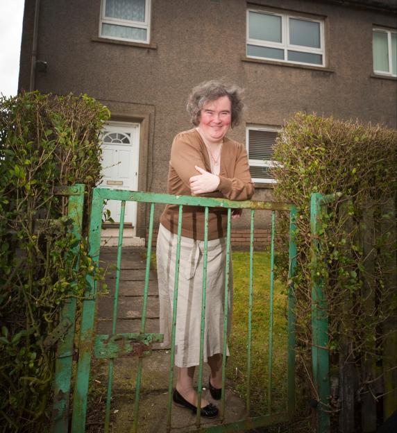 Susan Boyle leaning on her gate outside her home.