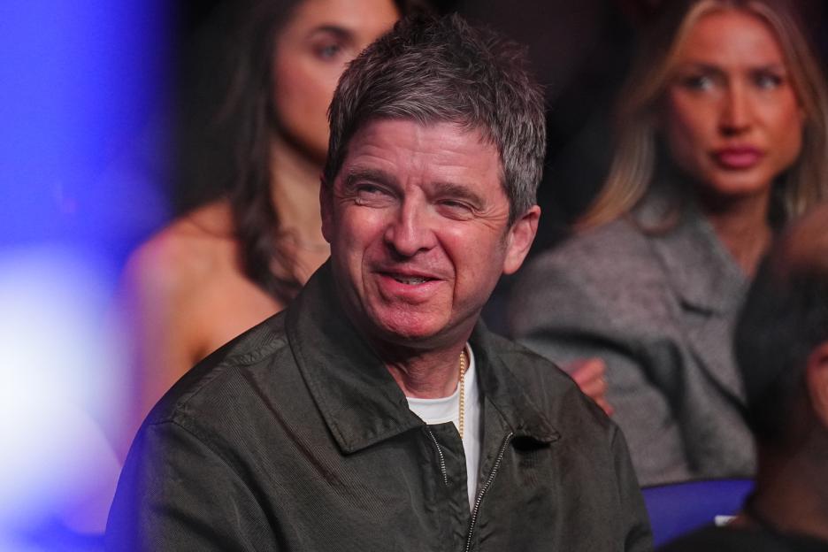 Noel Gallagher smiling while watching UFC Fight Night.