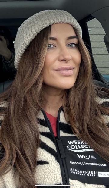A woman wearing a knit beanie and a black and white striped jacket with "WEEKEND COLLECTION" and "LONDON / UNITED KINGDOM" on it.
