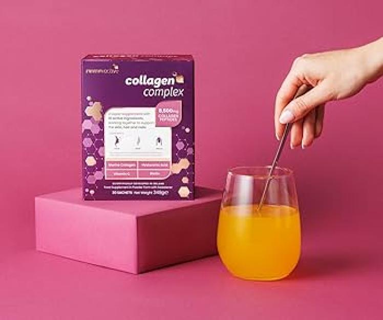 Revive Active Collagen Complex box and a hand stirring a glass of orange liquid.