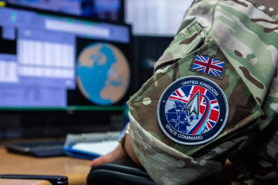 A UK Space Command badge and Union Jack flag on the sleeve of a camouflage uniform.