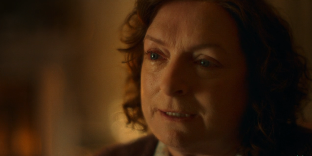 Close-up of a woman with tears in her eyes looking to the right.