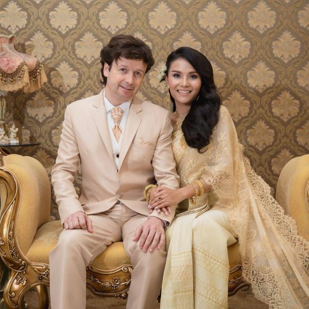 ASOS founder Quentin Griffiths and Ploy Kringsinthanakun sitting together on a gilded sofa.