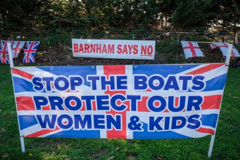 Banners and flags expressing opposition to the government's plan to open a migrant camp at MOD Barnham.