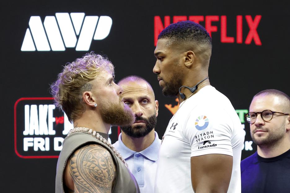 Jake Paul and Anthony Joshua face off at a press conference.