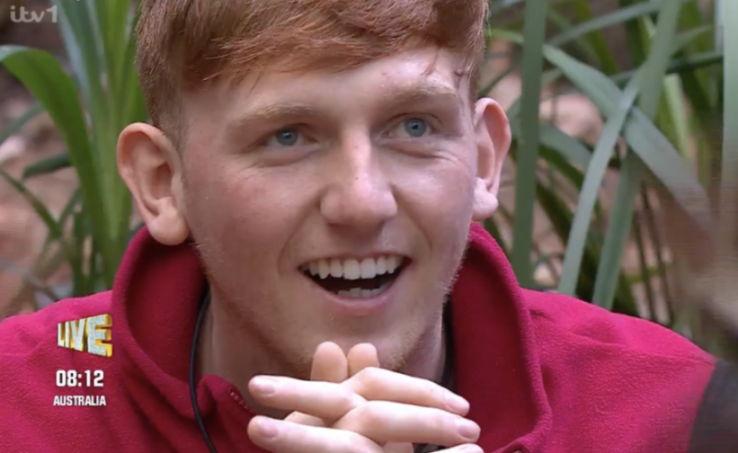 A red-haired man with blue eyes and a big smile on his face.