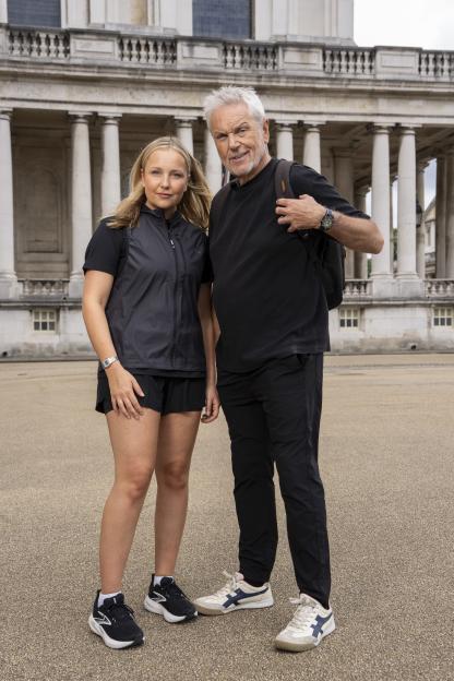 Lucy and Brian Conley smiling in front of the Old Royal Naval College in Greenwich.
