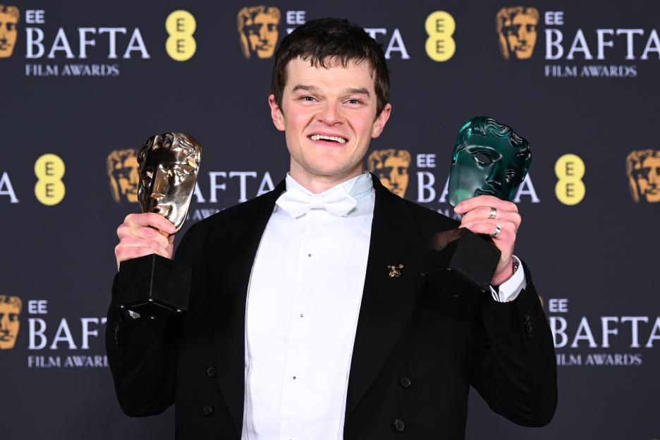 Robert Aramayo holding the Leading Actor Award and the EE Rising Star Award at the 2026 EE BAFTA Film Awards.
