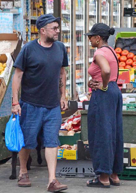 Blur frontman Damon Albarn and Rebecca Freckleton talking at a market stall.