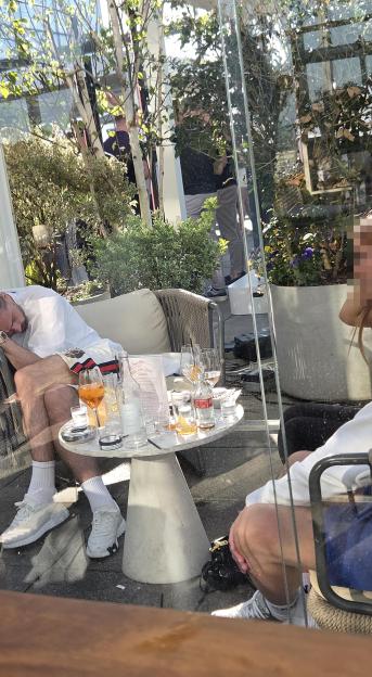 Jack Grealish asleep in a white armchair on a rooftop bar.